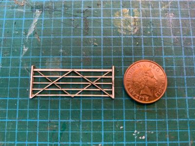 4mm scale 5 bar gate made from 3 layers of laser-cut card next to a penny.