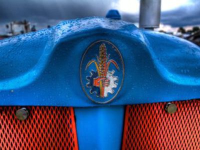 Red front grill of a blue Fordson tractor .