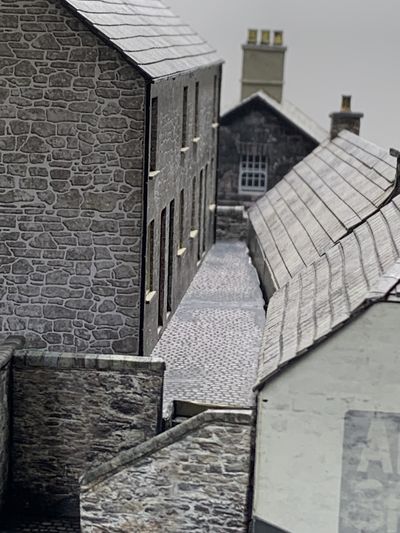 Small 3ft wall in the distance at the end of the back row of cottages alley.